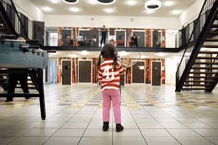 afbeelding kind spelend in hal van gevangenis