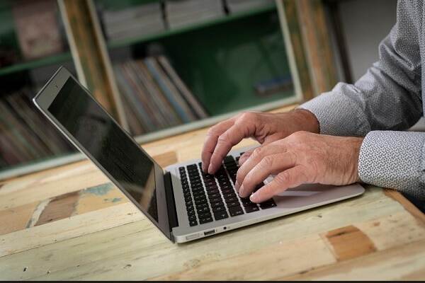 Afbeelding man achter laptop